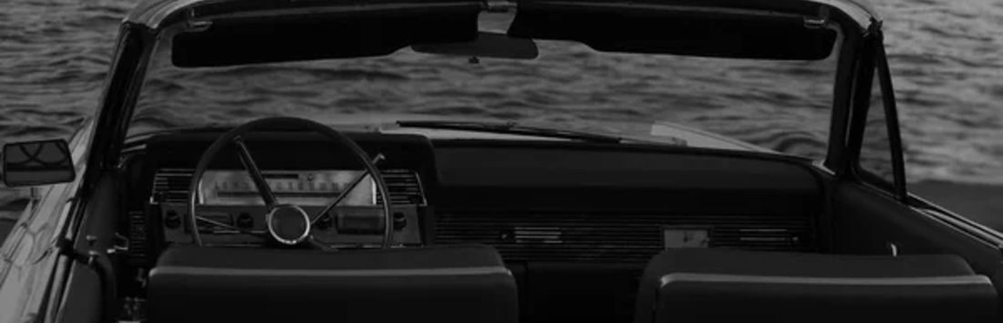 Coche descapotable negro frente al mar